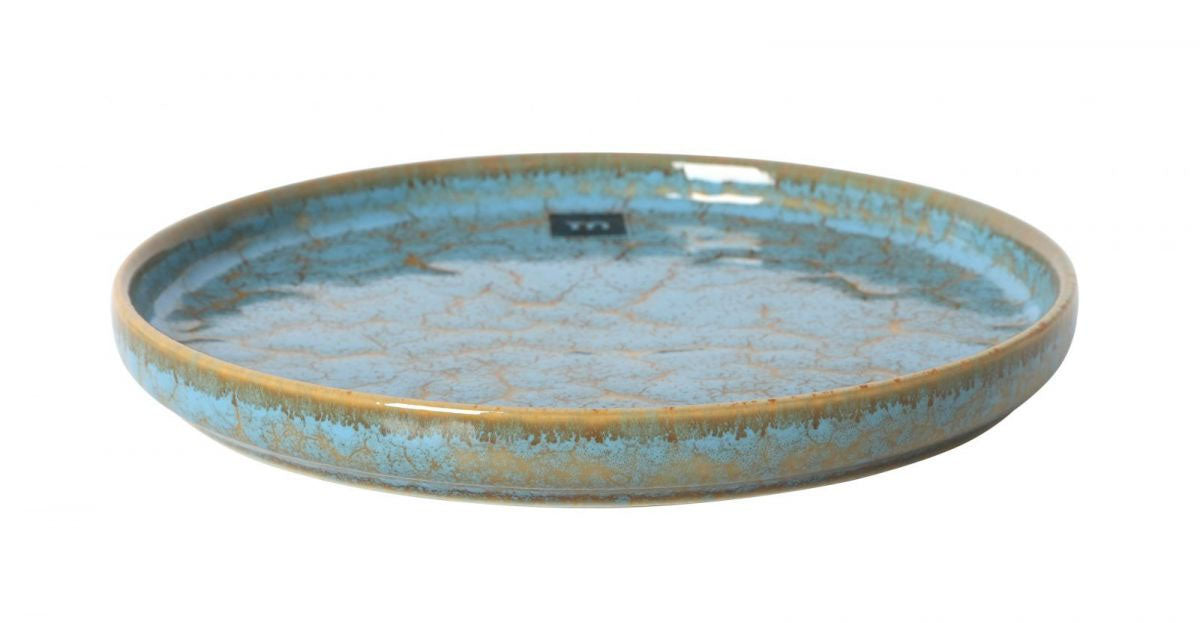 Round blue ceramic dessert plate with a shallow shape and golden-brown rim