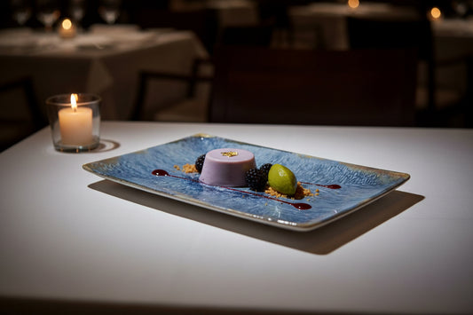 A rectangular ceramic plate with a textured blue and gray glaze and a rustic metallic gold-toned rim, shown against a plain white background.
