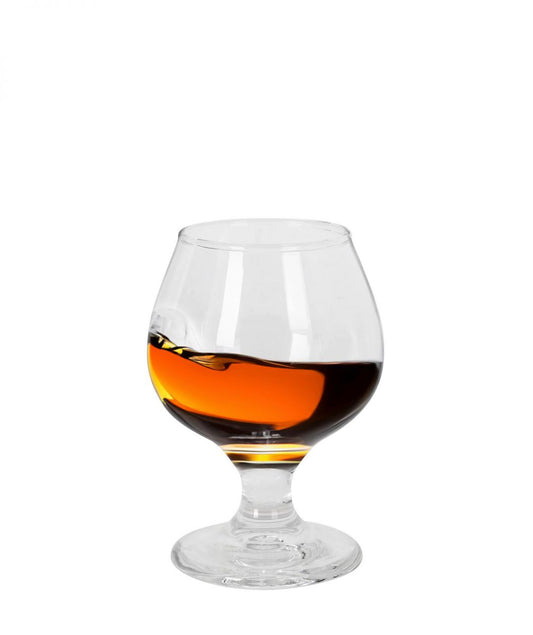 Brandy glass filled with brandy on a white background