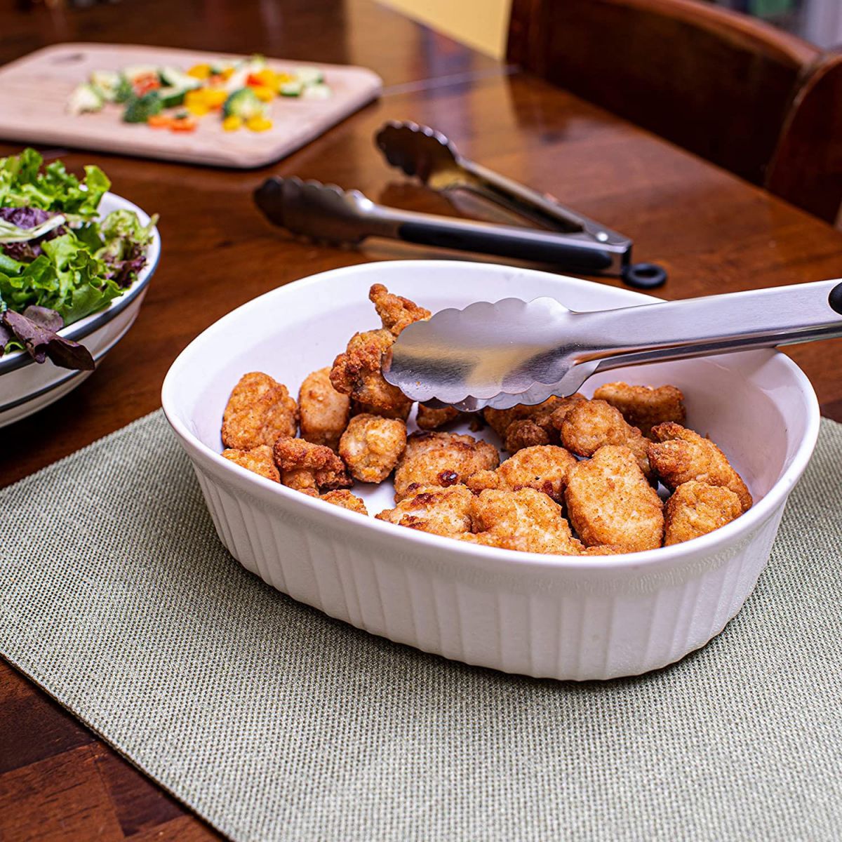 White ceramic baking dish with golden-brown fried chicken and Kitchen Tongs 28.5cm