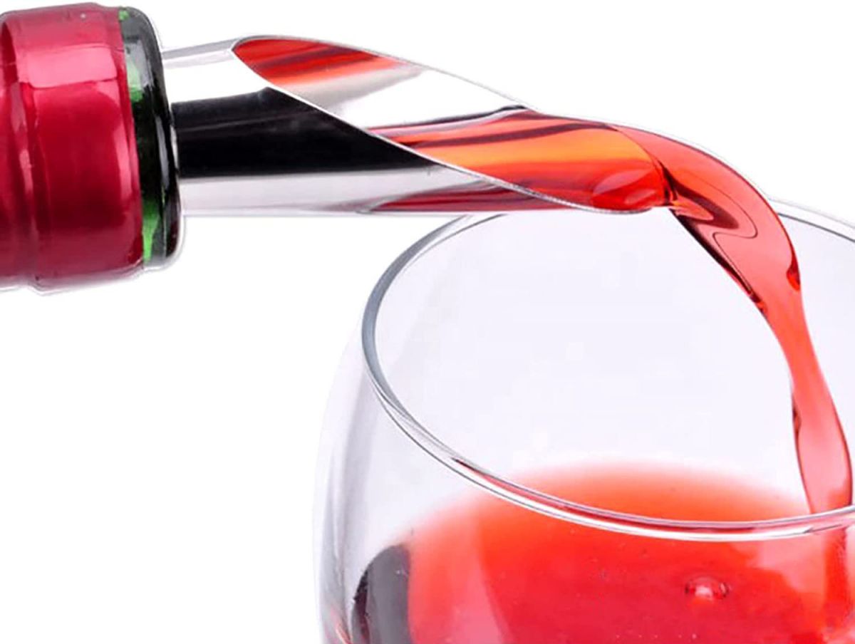 Red wine pouring into a glass from a stainless steel metal aerator wine bottle stopper