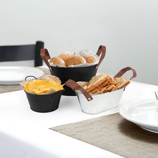 Set of three metal serving baskets with faux leather handles holding food items