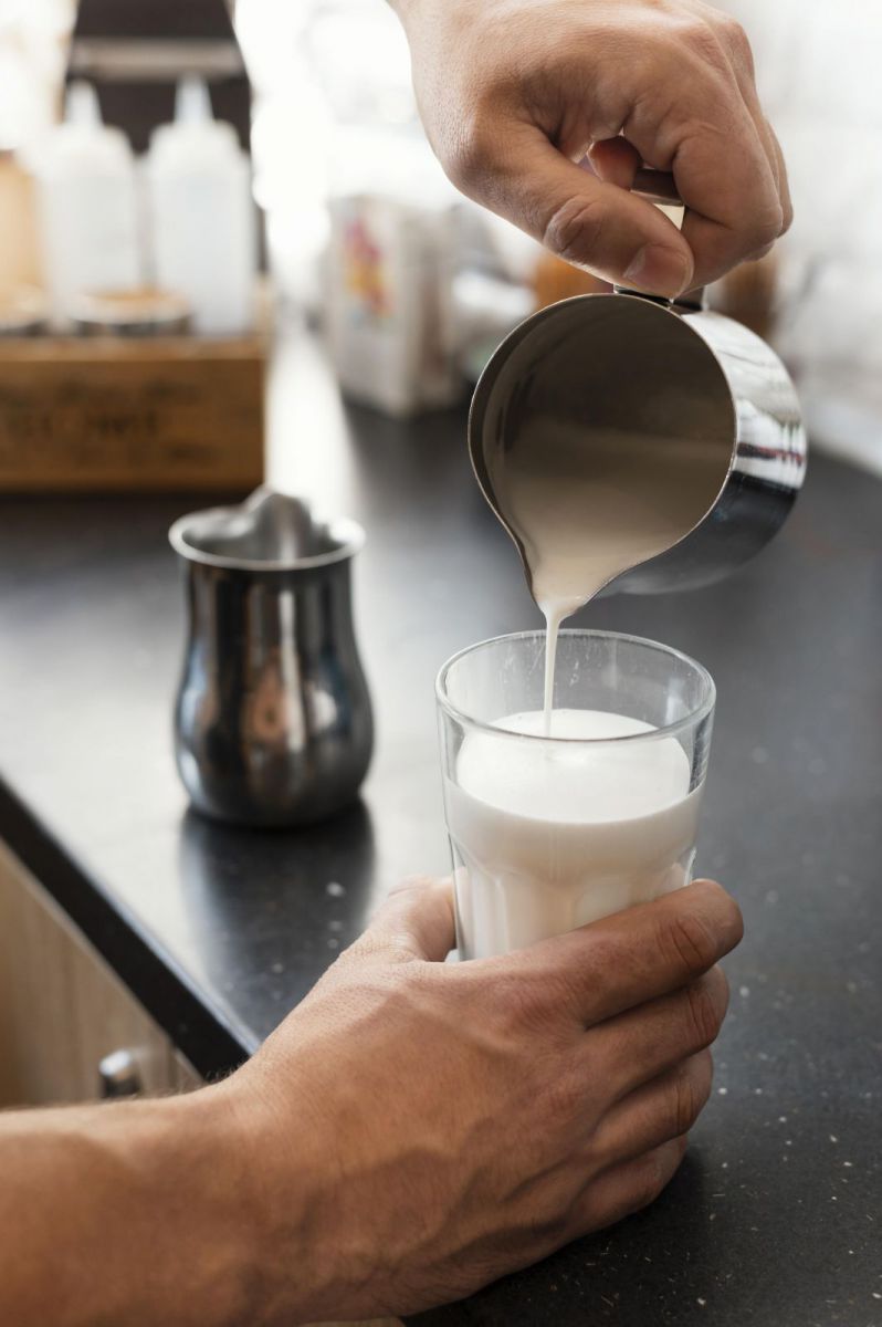 Milk being poured into a glass from a Stainless Steel Milk Coffee Frothing Jug 330ml